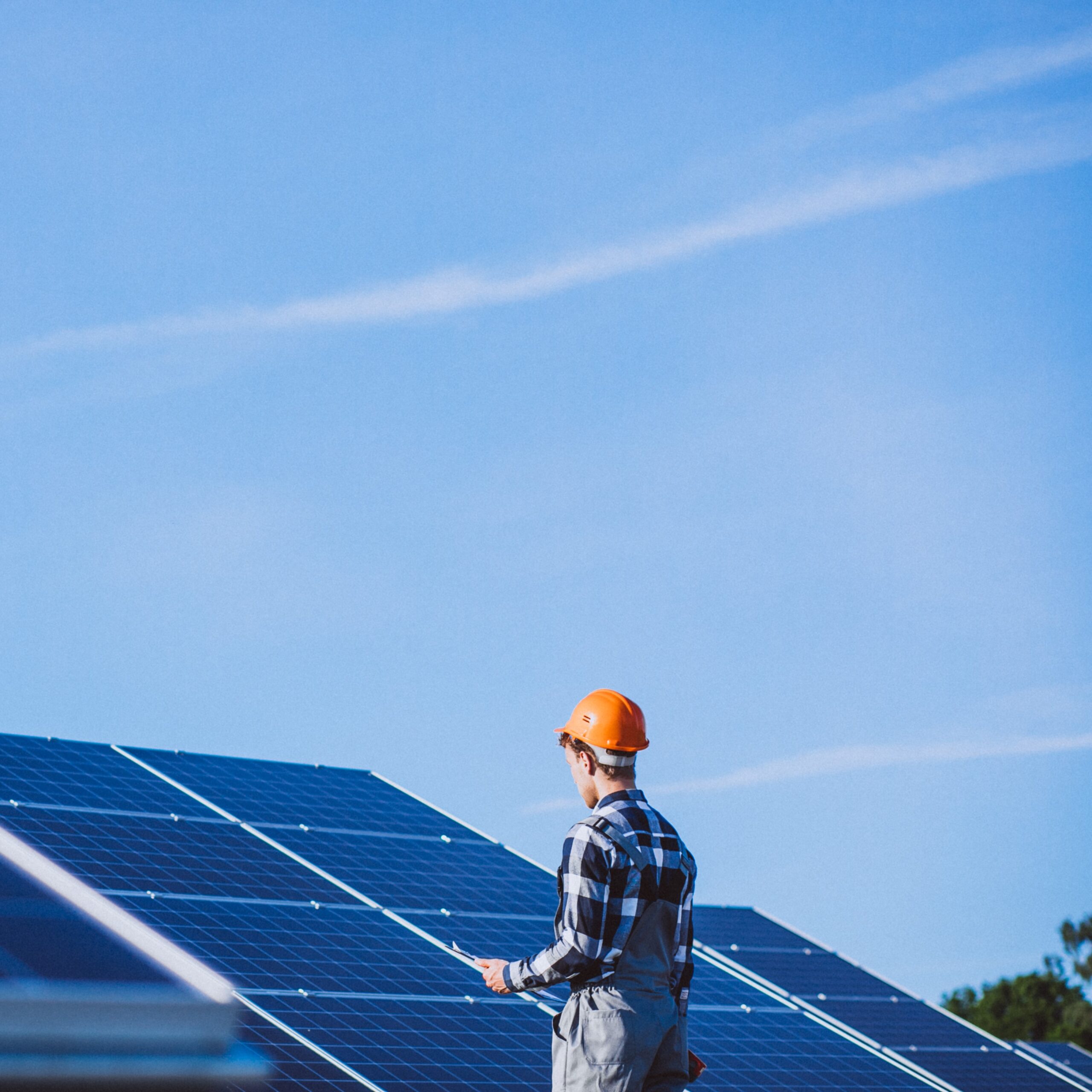 Man worker in the firld by the solar panels